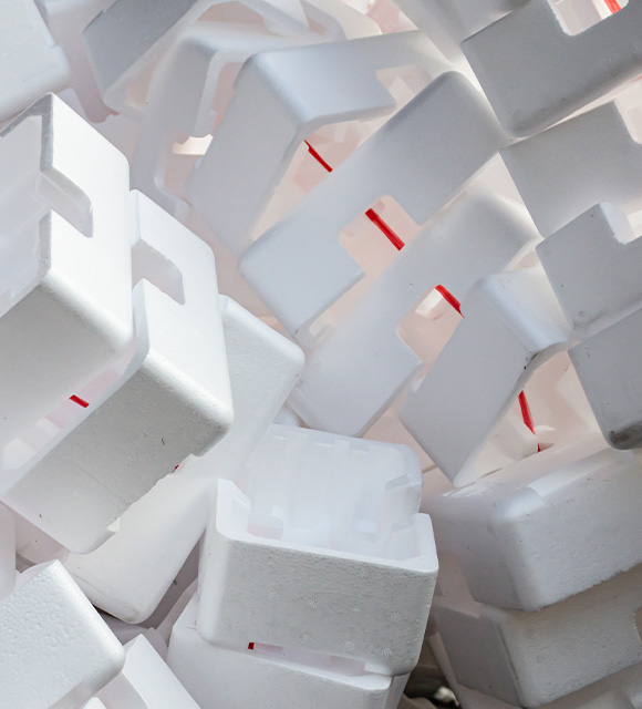 close-up of several white foam blocks stacked together with a hint of red peeking through ideal for packaging and stacking items in an 11 step process