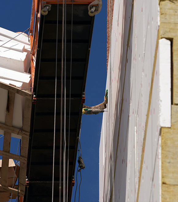 construction worker using scaffolding on building exterior under blue sky 9 safety measures repair 9 efficiency tools