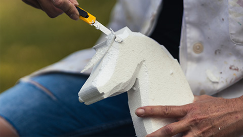 person sculpting a white foam horse head with a craft knife suitable for art projects and creative education 14 fun activities