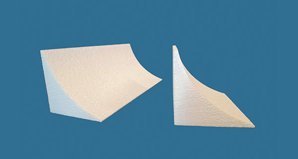 two white foam shapes on a blue background showing angular designs ideal for various applications