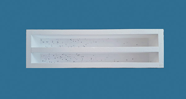 a white rectangular object with two parallel sections containing small black particles on a blue background ideal for artistic display and projects involving 8 elements